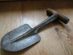 an old metal shovel laying on top of a wooden floor