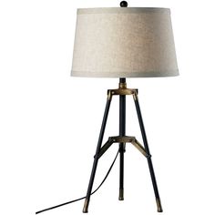 a lamp that is sitting on top of a wooden tripod stand with a beige shade