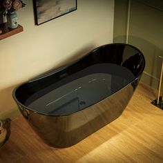 a bathtub sitting on top of a wooden floor next to a vase filled with flowers