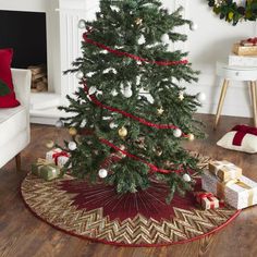 a decorated christmas tree in a living room with presents on the floor next to it