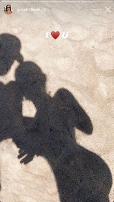 the shadow of a person holding a cell phone in front of their face, with an i love you sticker on it