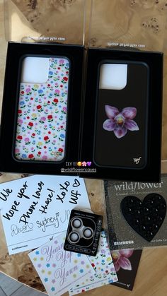 two cases with flowers and hearts are on the table next to some cards, brochures, and other items