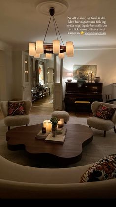 a living room filled with furniture and a chandelier hanging over the top of it