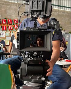 a man sitting in front of a camera on top of a table