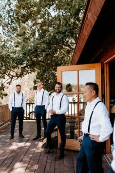 a group of men standing on top of a wooden deck