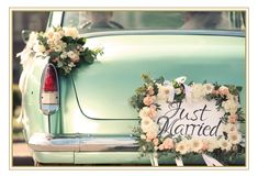 a wedding car decorated with flowers and just married sign