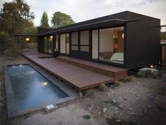 a small house with a pool in the yard and decking area next to it