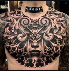 a man's chest with an intricate tattoo design on the top and bottom part