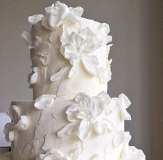 a white wedding cake with flowers on the top and bottom is displayed for instagram