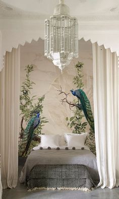 a bedroom with two peacocks sitting on the bed and curtains hanging from the ceiling