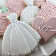 decorated cookies in the shape of wedding gown and bride's dress on a plate