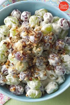 a blue bowl filled with grapes and nuts