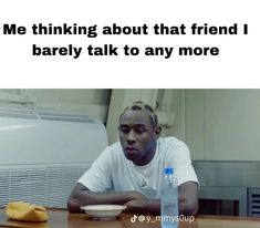 a man sitting at a table with a bottle of water in front of him and the caption reads, me thinking about that friend i barely talk to any more