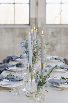 the table is set with candles and plates