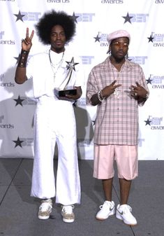 two black men standing next to each other on a red carpet with stars around them