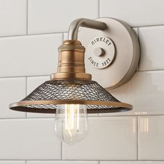 a light that is on the wall next to a white tiled wall and some lights