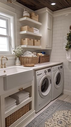 a washer and dryer in a white laundry room with baskets on the wall