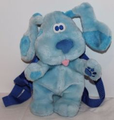 a blue stuffed animal sitting on top of a white table