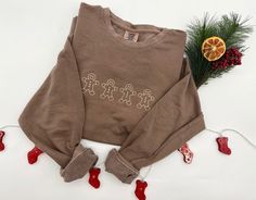 "GINGERBREAD MEN EMBROIDERED CREW NECK SWEATSHIRTS! This is the perfect gift for this holiday season.  I M P O R T A NT .  P L E A S E . R E A D . C A R E F U L L Y ---------------------------------------------------------------------------- { D E T A I L S } The Sweatshirts are Light Weight Comfort Colors Crewnecks:  - Garment-dyed for that lived in feel and almost no shrinkage at home. - Soft ring spun cotton fabric with 100% cotton threads - Relaxed fit - 1x1 rib collar, cuffs and waistband - Rolled forward shoulder - Back neck tape  T I M E ∙ T O ∙ D E L I V E R Y : -->Processing & production time is 3-5 days. -->Delivery time varies depending on your delivery address. E M B R O I D E R Y . O R D E R . I N S T R U C T I O N S Embroidery length is 8\".  Embroidery height is 2.5\".  Cust Christmas Embroidery Sweatshirts, Cute Embroidered Sweatshirt, Embroidered Christmas Sweatshirt, Christmas Sweatshirts Vinyl, Embroider Sweatshirts, Sweatshirt And Shirt Outfit, Christmas Sweatshirt Ideas, Xmas Clothes, Unisex Christmas Gifts