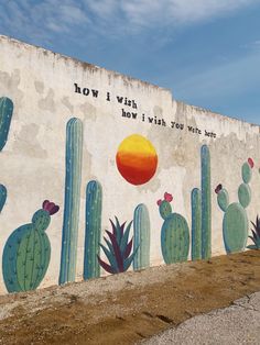 a large mural painted on the side of a building with cactus and sun in it