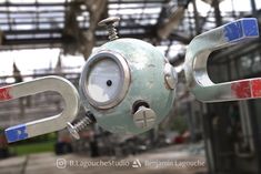 a close up of a metal object with a clock on it's face and eyes