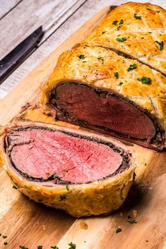 a sliced meatloaf sitting on top of a wooden cutting board