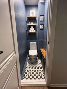 a small bathroom with blue walls and black and white floor tiles on the shower wall