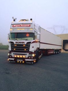 a semi truck is parked in front of a building with lights on it's cab