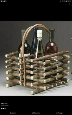 a wine bottle holder made out of wooden sticks and logs with bottles in them sitting on a table