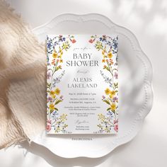 a white plate with a baby shower on top of it next to a napkin and cloth