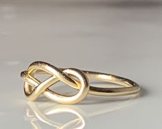 were highly symbolic in vintage jewelry, symbolizing infinite love. This would make a wonderfully unique wedding or engagement ring due to the romantic symbolism. The love knot/infinity knot represented the union of two souls arranged in the form of an infinity love knot. :) Ring weighs 1.3 grams. Band is stamped for 14k gold and is nice and sturdy despite it's dainty appearance. The ring is very comfortable to wear due to the low profile. The setting face measures 12.5 mm E to W and 8 N to S. C Infinity Ring Detail Wedding Jewelry, Wedding Infinity Jewelry With Ring Detail, Symbolic Infinity Jewelry For Anniversary, Cabin Core Aesthetic, Infinity Knot Ring, Cabin Core, Love Knot Ring, Infinity Knot, Engagement Ring Inspiration