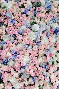 many different colored flowers are arranged in the shape of a flower arrangement, as well as blue and pink blooms