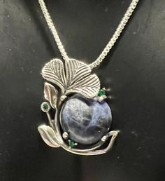 Gemstone: genuine natural round cab cut sodalite Size: 13mm Weight: approx 8cts Accent stone: 3 genuine natural round cut emerald Size: .5mm Color: green Metal: .925 stamped Sterling Silver Chain: 20" stamped Sterling Silver, 1mm box chain Total weight of necklace: 8g Price: $129.99 Elegant Round Sodalite Jewelry, Natural Stones May Birthstone Gemstones, Round Natural Gemstones For May Birthstone, May Birthstone Natural Round Gemstones, Round Natural Stones For May Birthstone, Round Natural May Birthstone Gemstones, Round Natural Emerald Gemstones, Green Metal, Box Chain