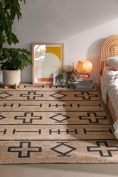 a bed room with a neatly made bed and a rug on the floor next to it