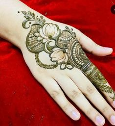 a woman's hand is decorated with hennap and flowers on red velvet