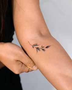 a woman's arm with a small tattoo on the left side of her arm