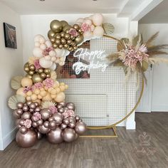 a birthday party with balloons and flowers on the wall in front of a circular mirror