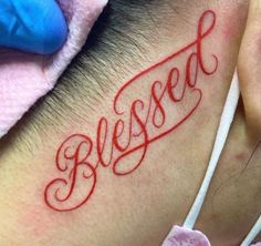 a close up of a person with a tattoo on their neck that says, blessed