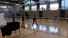 a group of people on a court playing volleyball