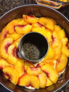 a bowl filled with sliced peaches on top of a counter next to an empty container