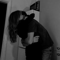 two people hugging each other in front of a microwave