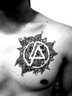 a man with a tattoo on his chest has an anarchy symbol in the middle of it