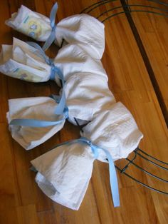 several rolls of toilet paper wrapped in blue ribbon on the floor next to a wire rack