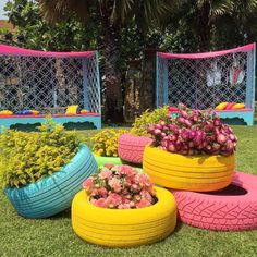 colorful tire planters are sitting in the grass