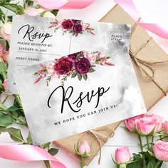 wedding rsp card with roses on it and pink ribbon around the envelope, next to some flowers