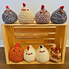 four crocheted chickens sitting on top of a wooden shelf next to each other