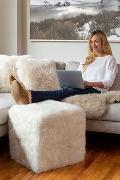 a woman sitting on a couch using a laptop