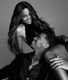 a man is holding a woman on his back while they are posing for a black and white photo