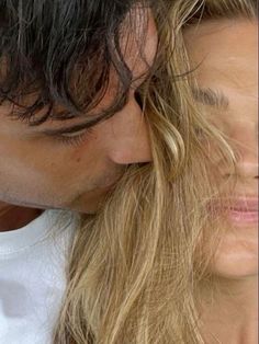 a man and woman kissing each other with long hair