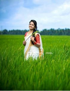 a woman standing in the middle of a lush green field